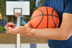 man experiencing hand injury from playing basketball